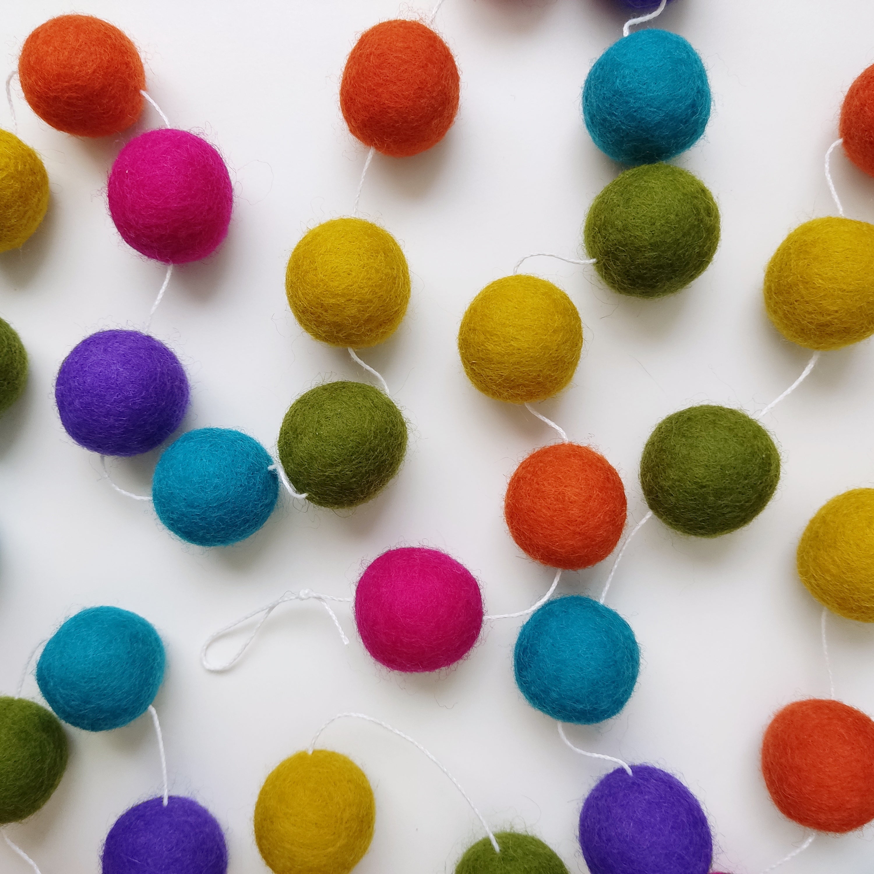Boules de feutre de la guirlande de pompons arc-en-ciel mexicain étalés sur une table