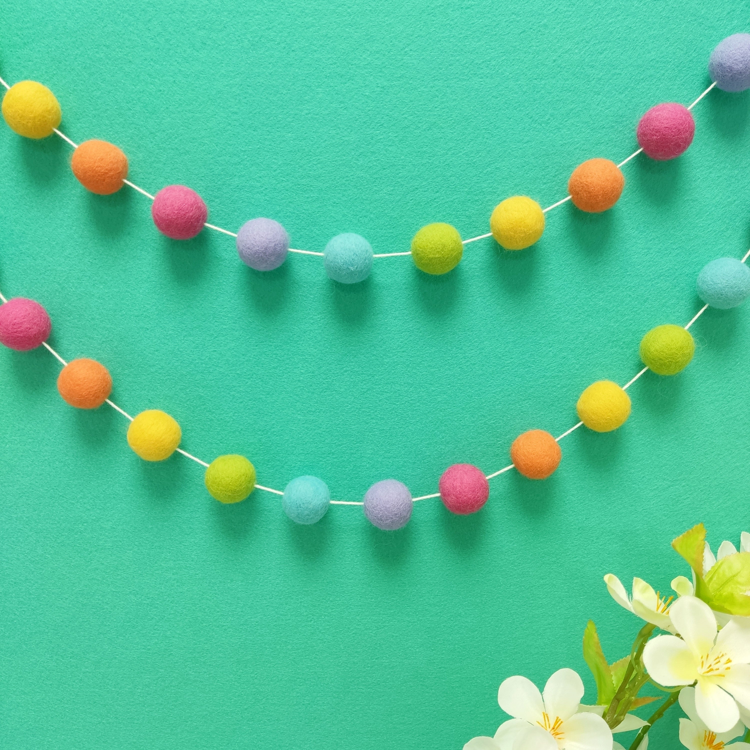 Guirlande de pompons feutrés multicolores arc-en-ciel suspendue en décoration murale, faite main en France — CELAINEDECO