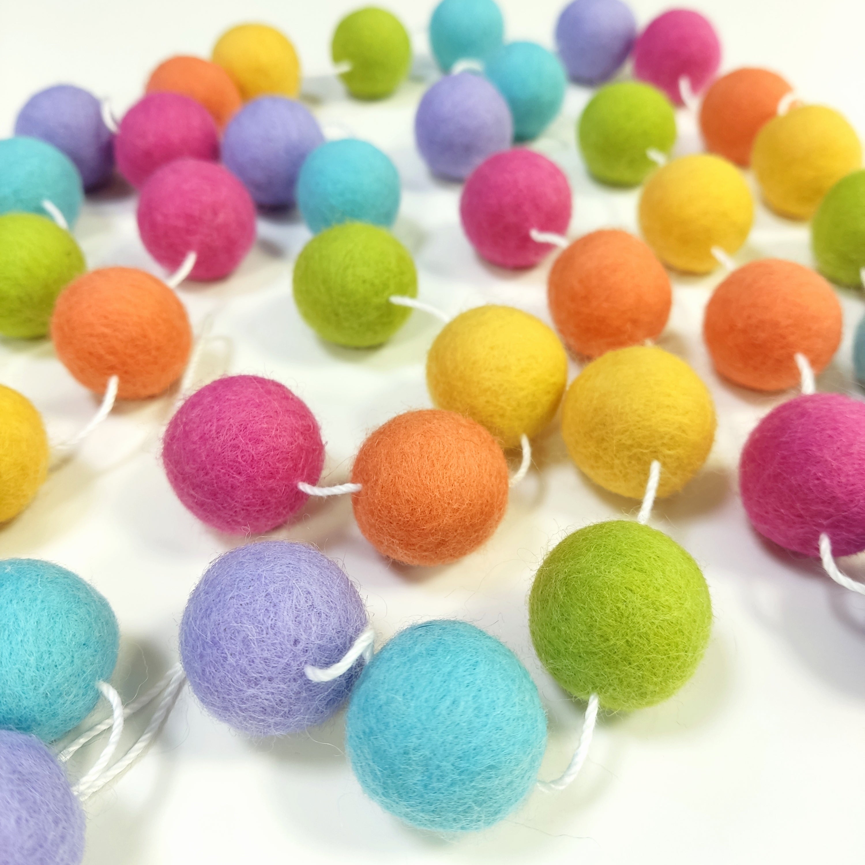 Guirlande de boules de laine feutrée étalée sur une table