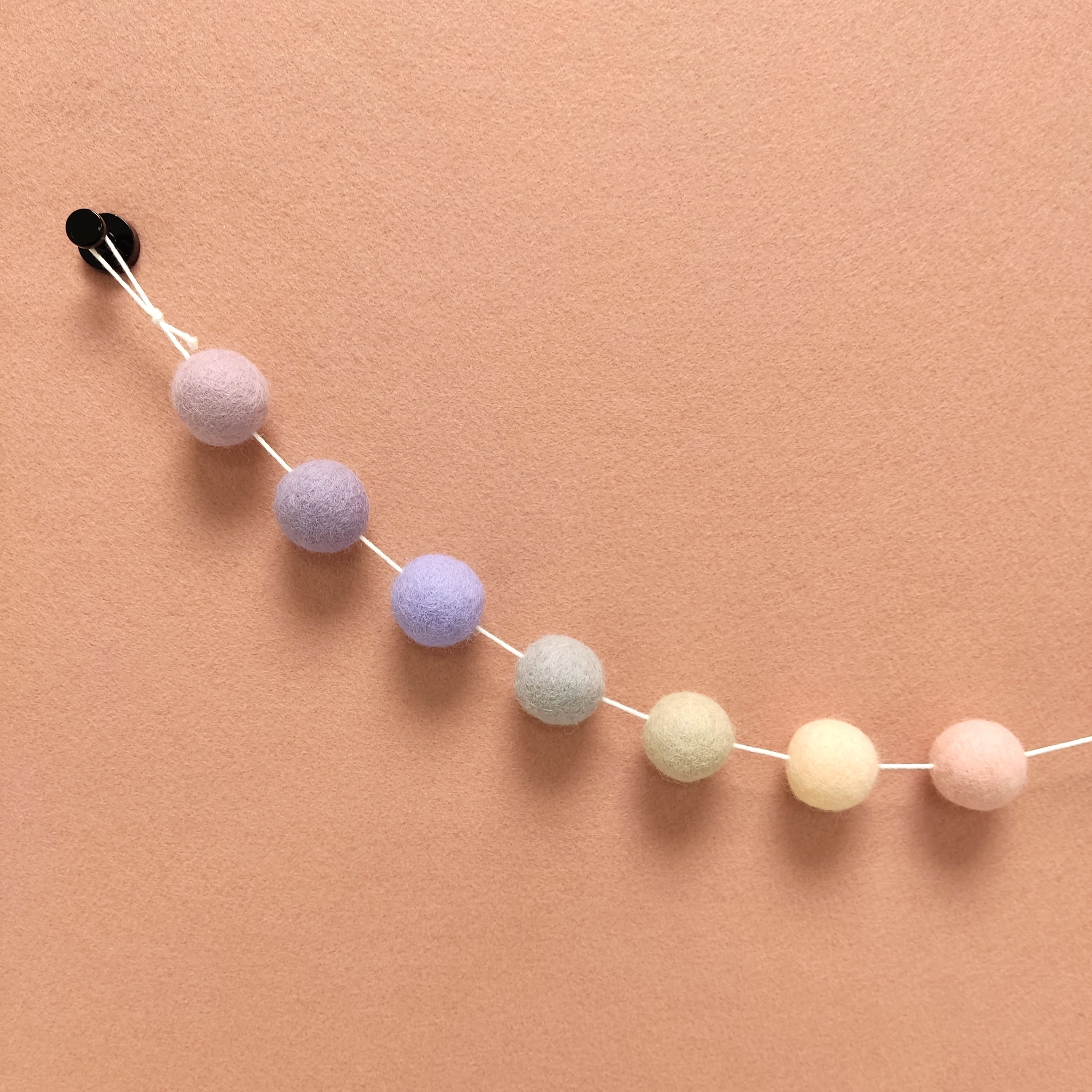 Détails des 7 couleurs de pompons feutrés lilas, mauve, lavande, mauve cendré, beige argile,beige rosé et rose poudré, de la guirlande Brume Lavande