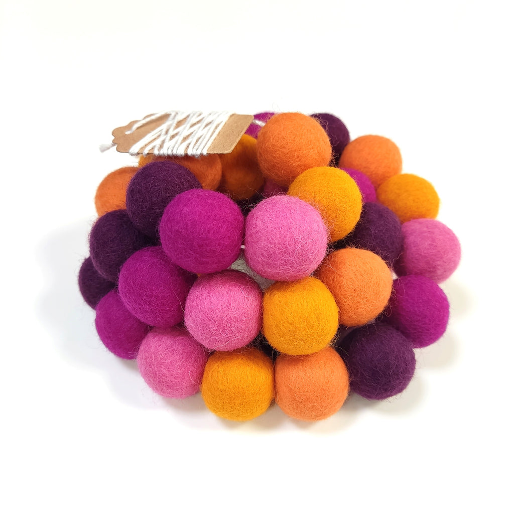 Zoom sur la guirlande de pompons feutrés dahlias avec étiquette