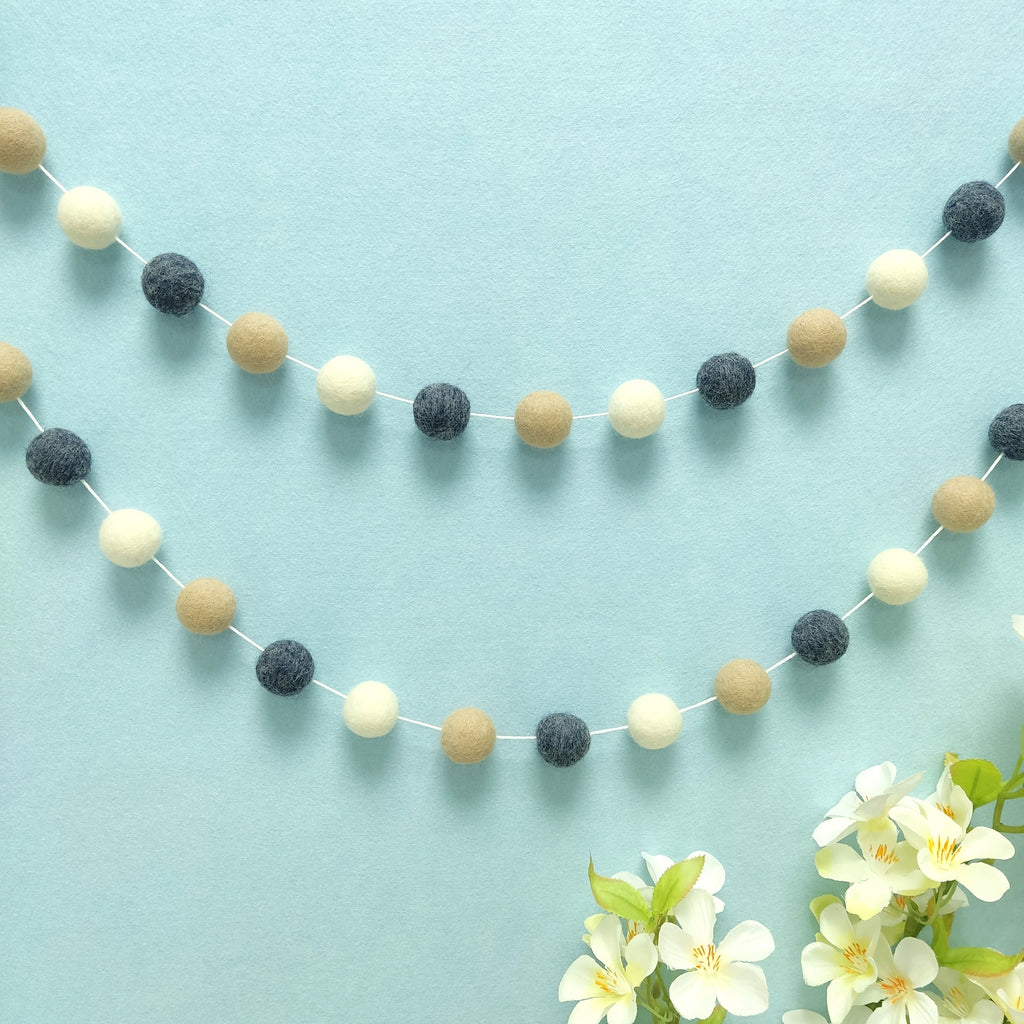 Guirlande de pompons denim beige fixée en décoration murale