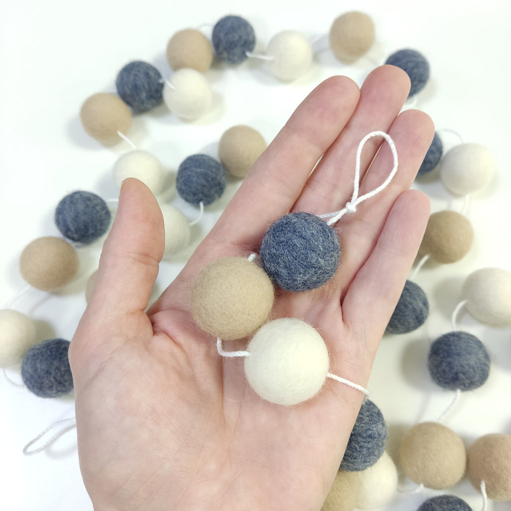 Détails des pompons feutrés de 2,5 cm denim beige blanc dans une main