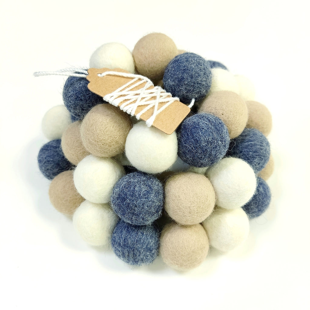 Guirlande de pompons en feutre bleu denim blanc et beige avec étiquette