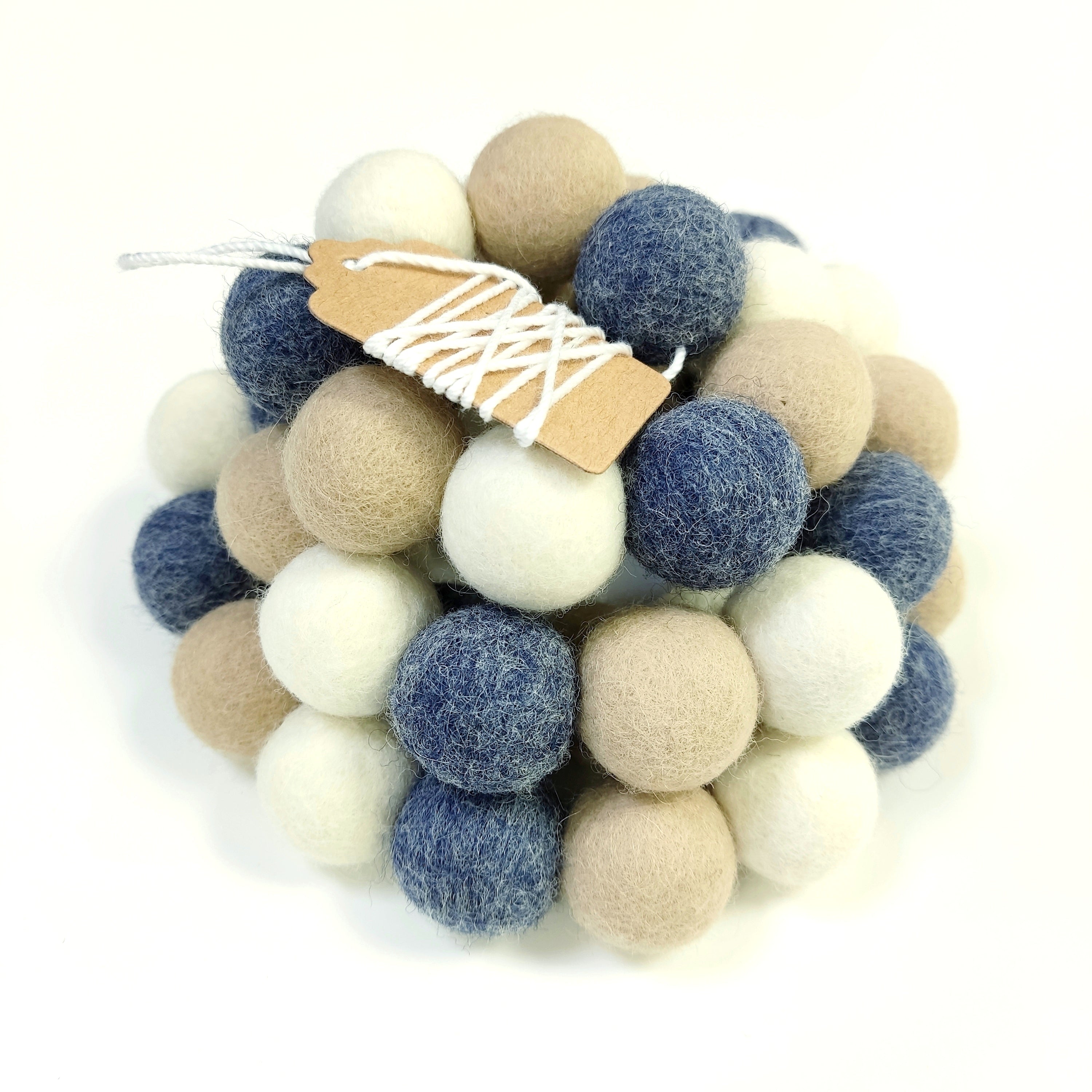 Guirlande de pompons en feutre bleu denim blanc et beige avec étiquette