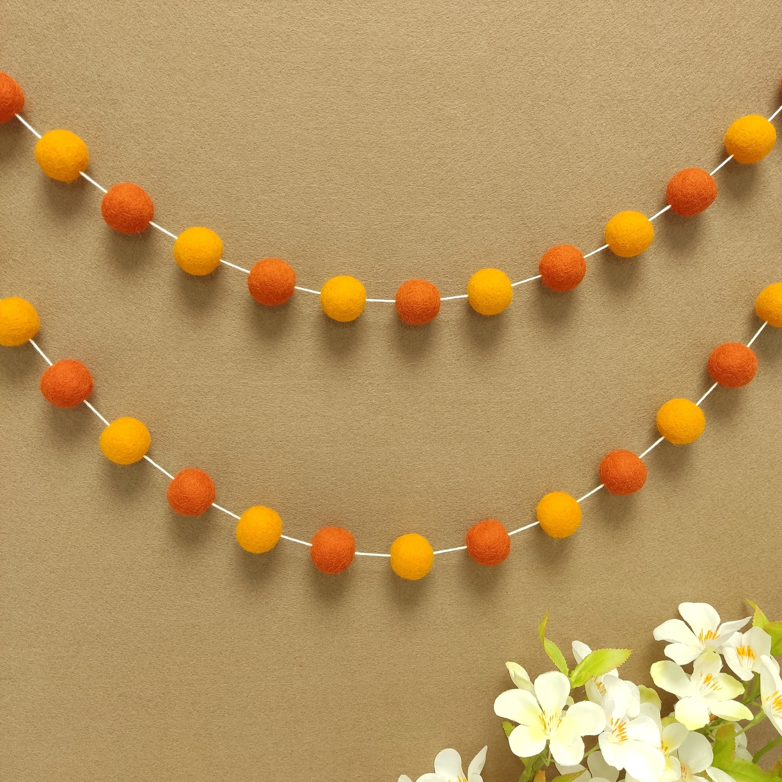 Guirlande décorative murale duo orange vue de loin fixée en arc de cercle