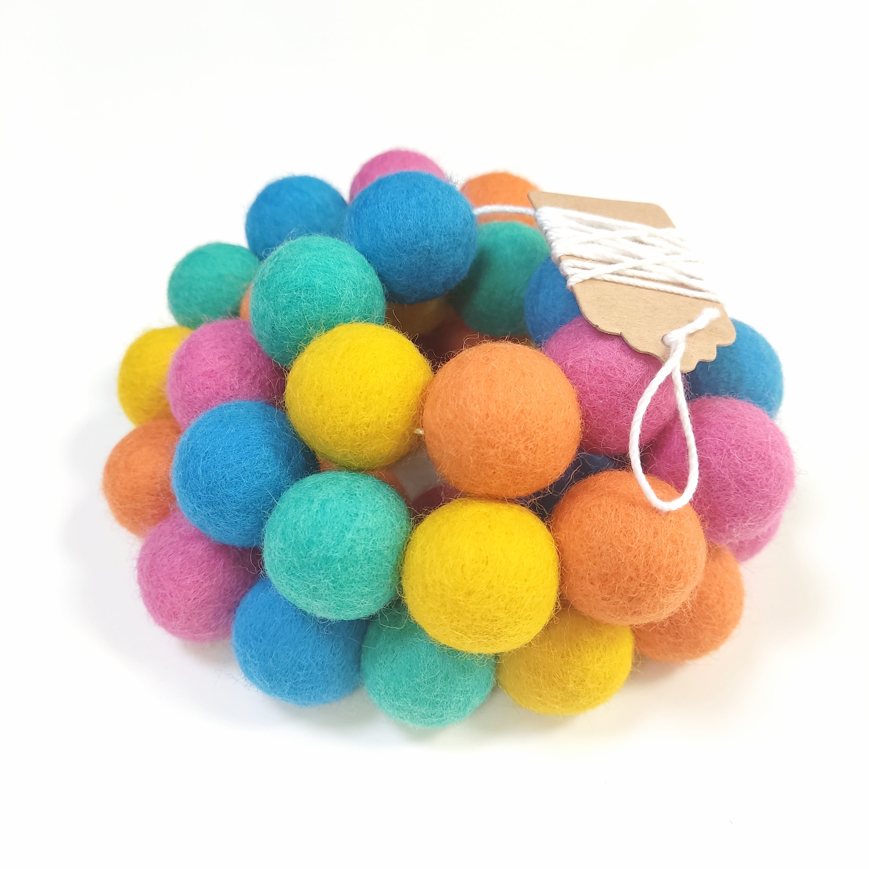 Zoom sur la guirlande flashy avec les pompons rassemblés sur le fil et l'étiquette