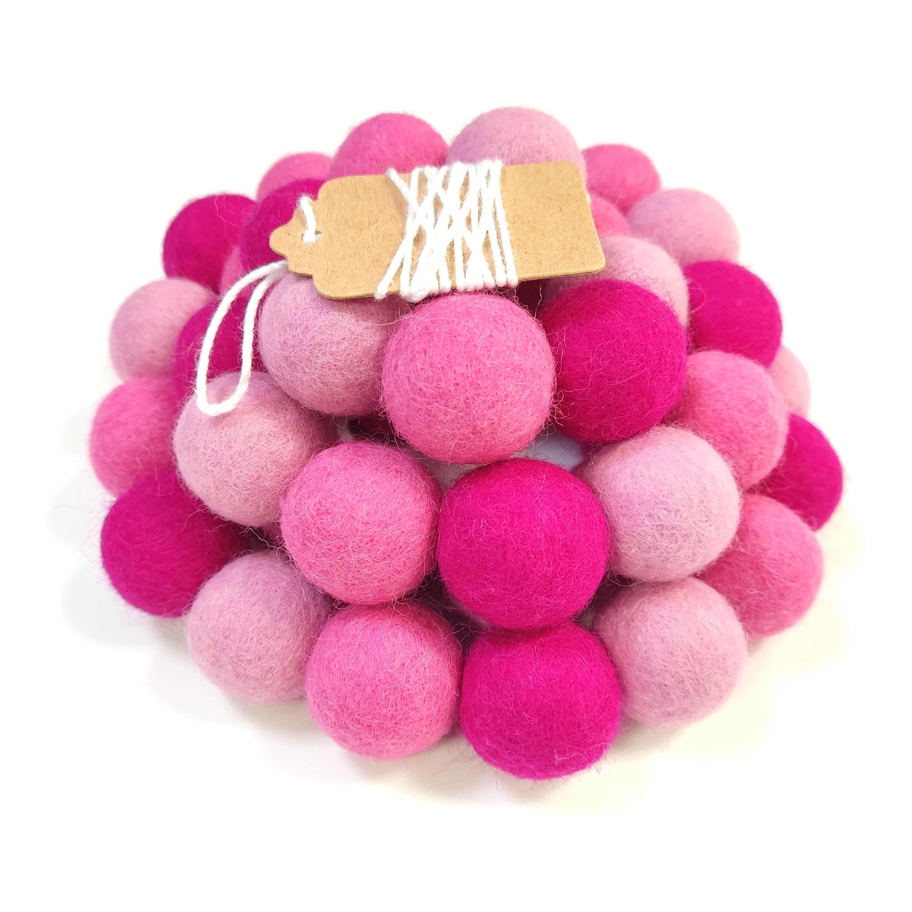 Zoom sur la guirlande de pompons feutrés aux tons roses avec son étiquette