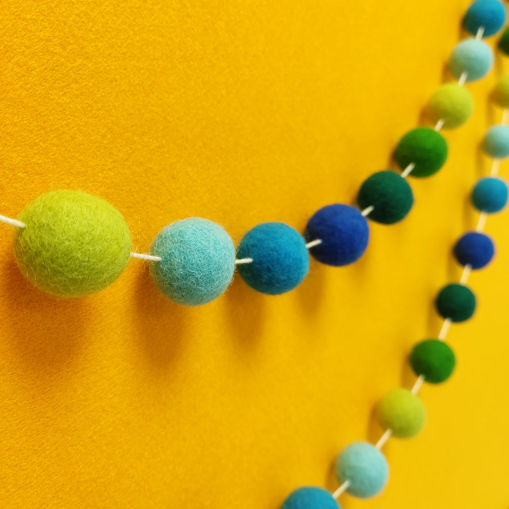 Guirlande de pompons en feutre de laine mérinos bleu et vert vue de profil