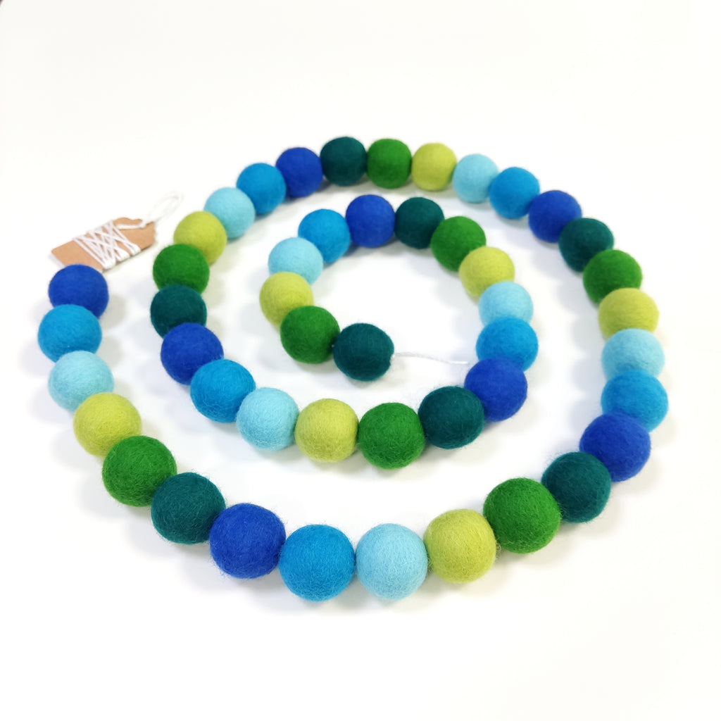 Guirlande pompons de feutre bleu vert en forme de spirale vue de dessus