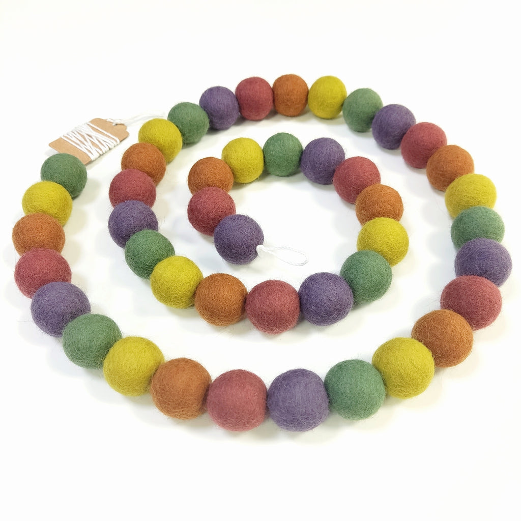 Guirlande de pompons multicolore vintage disposée en spirale sur une table