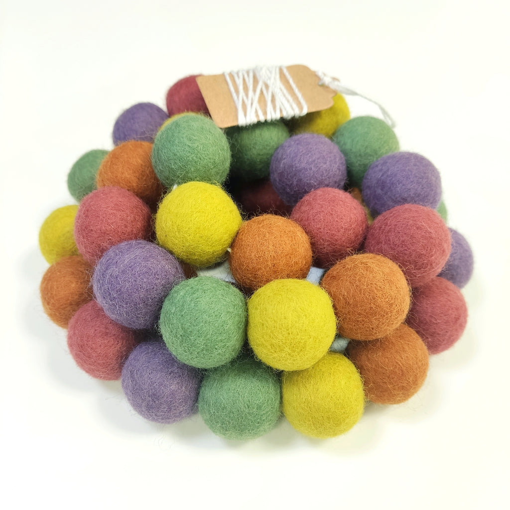 Guirlande de pompons feutrés multicolore vintage vue de près avec étiquette