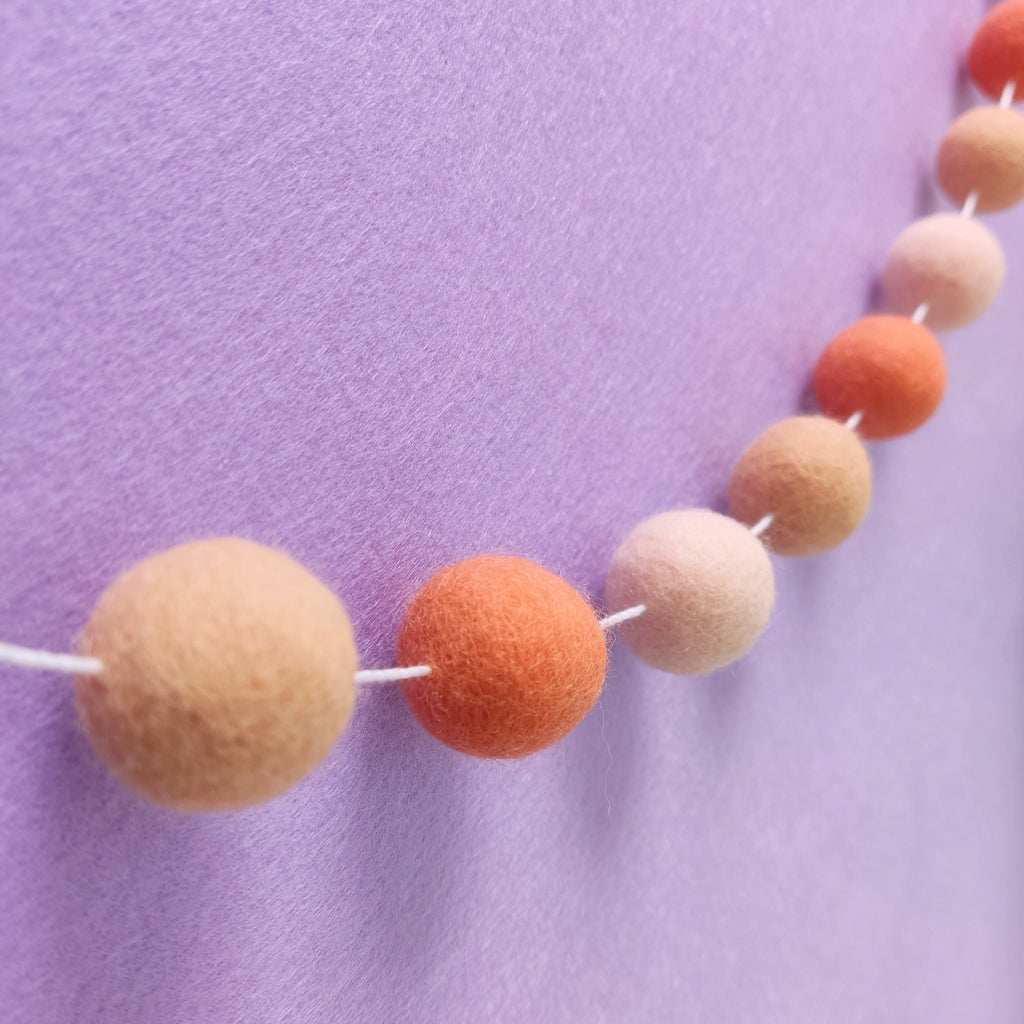Guirlande de pompons orange flamingo vue de profil