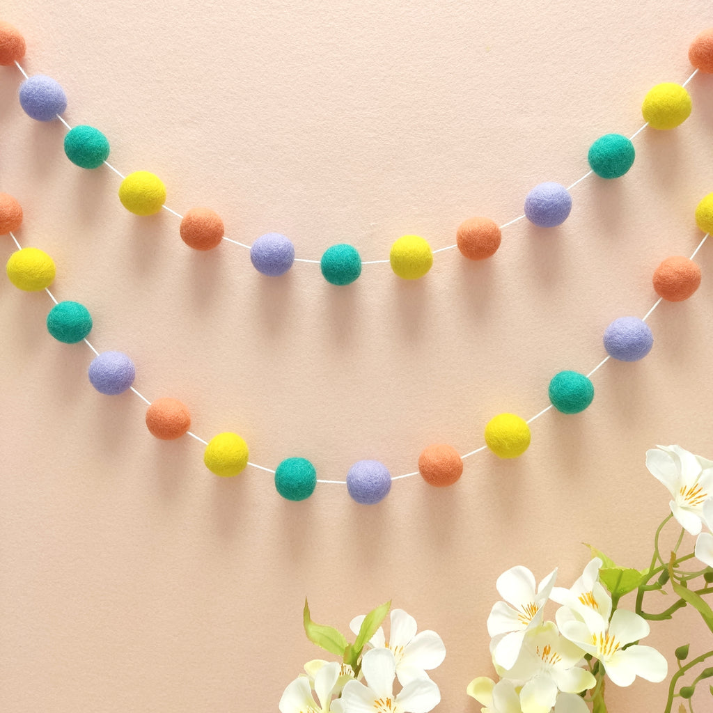 Guirlande de pompons feutrés pastel pop vue de loin
