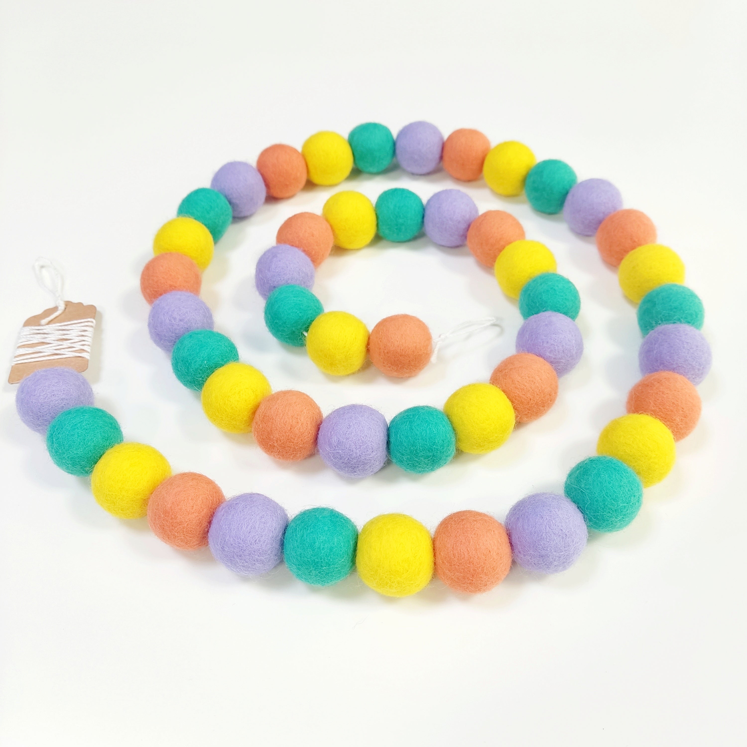 Gurilande de pompons feutrés pastel pop en spirale vue de dessus