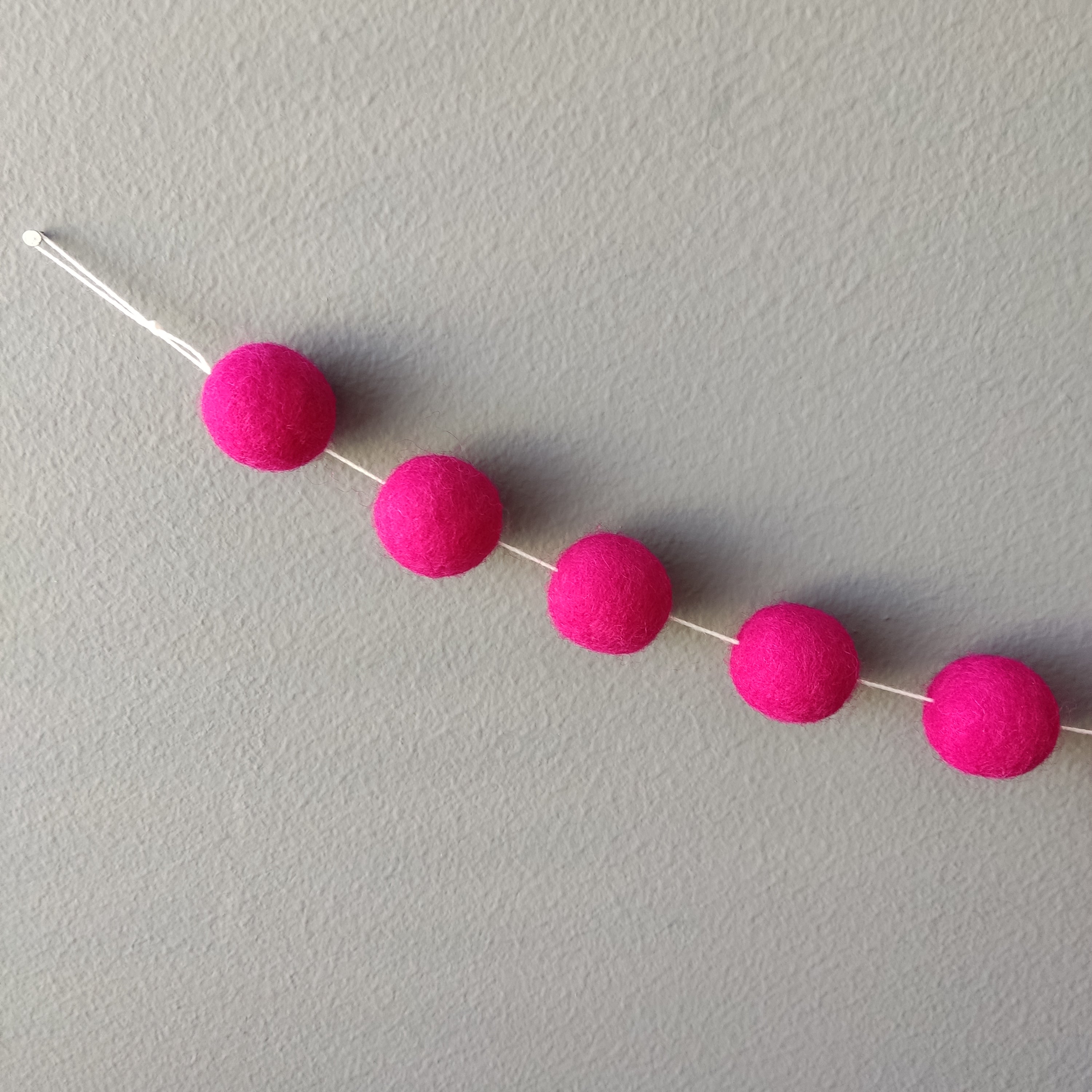 Zoom sur les pompons de feutre en laine mérinos rose magenta