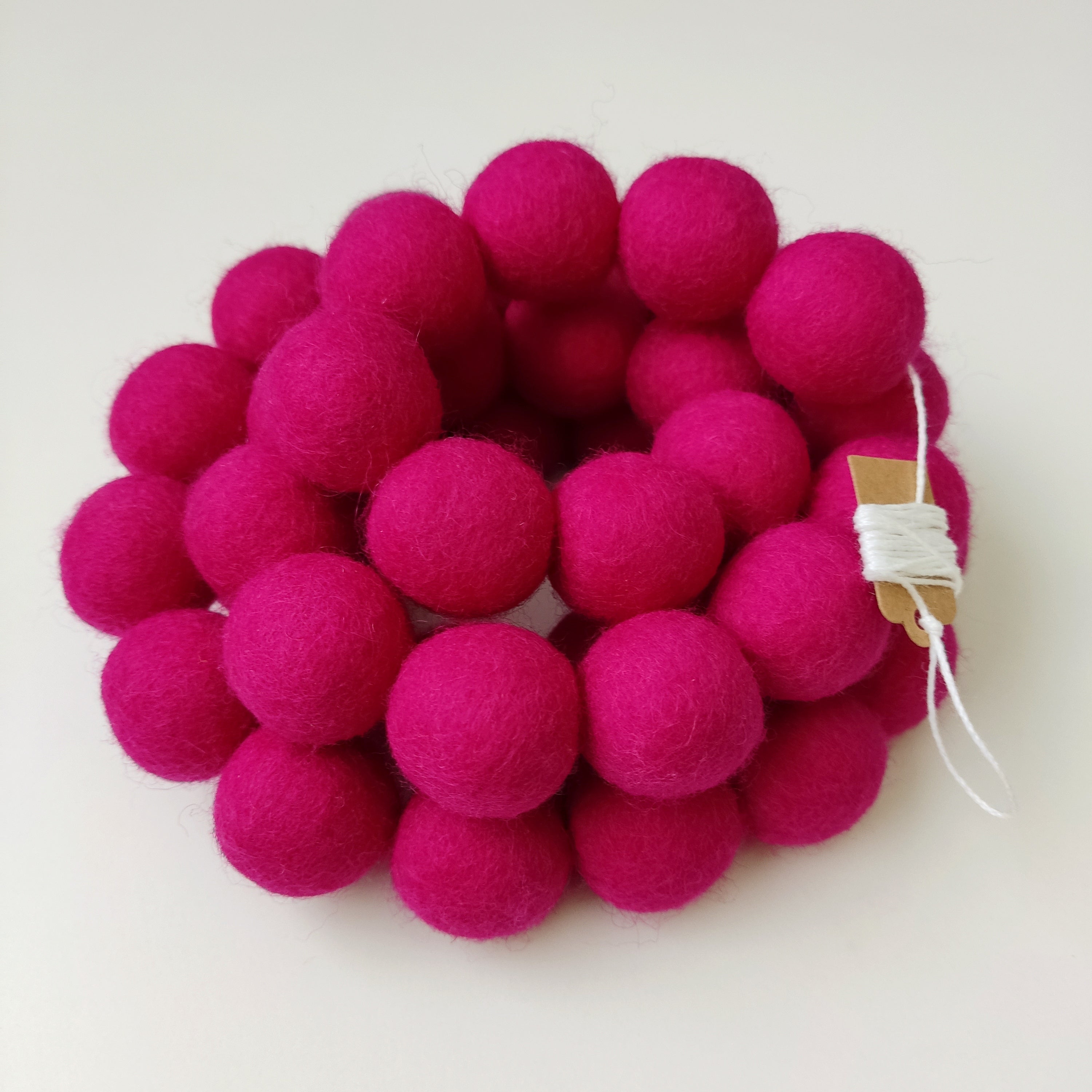 Guirlande de pompons rose enroulée sur elle-même