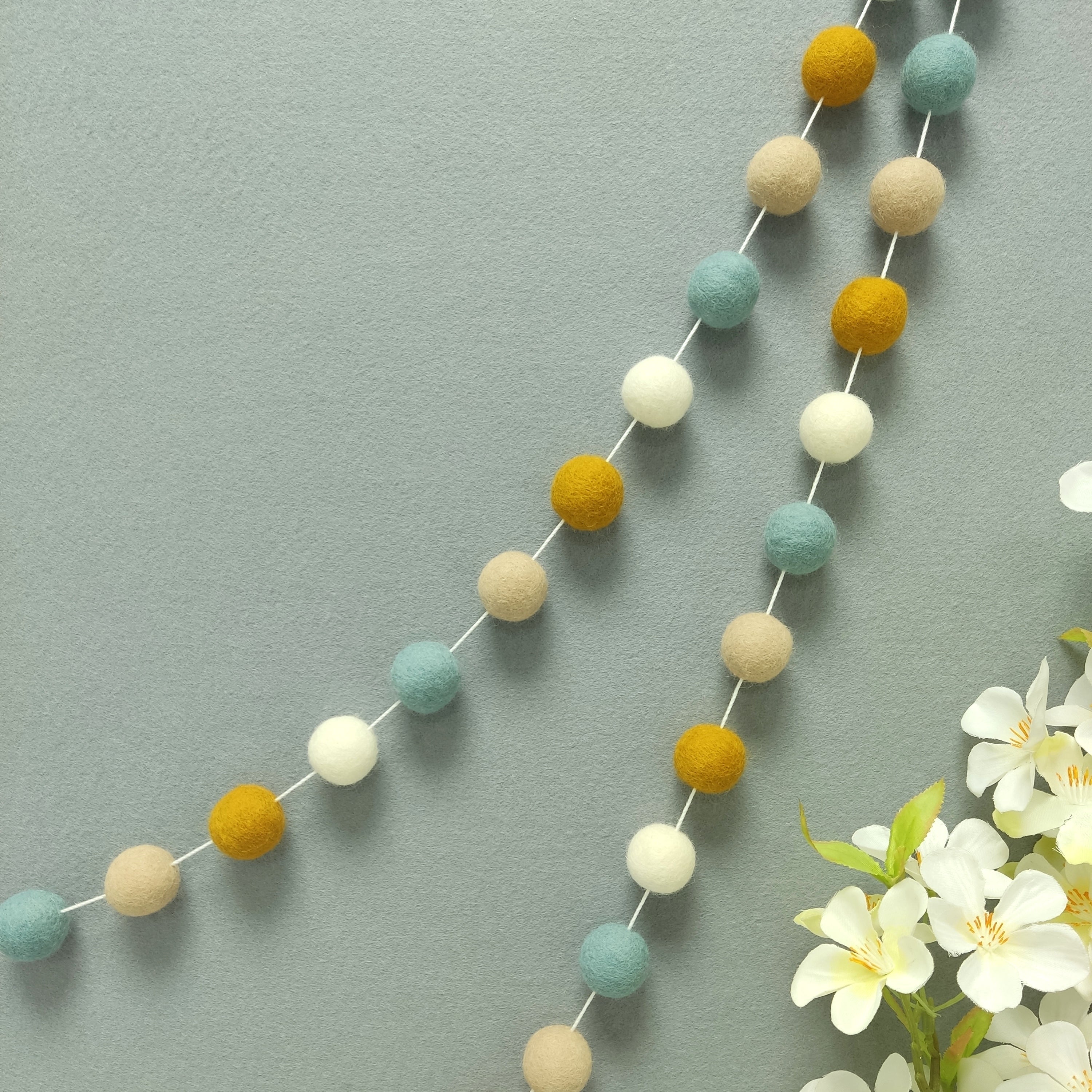 Guirlande de pompons scandinave vue de près en décoration murale