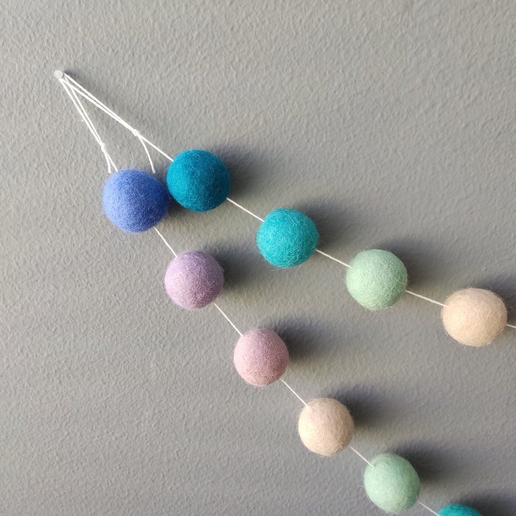 Détail de la boucle de fixation de la guirlande de pompons feutrés sirène en laine mérinos, faite main en France