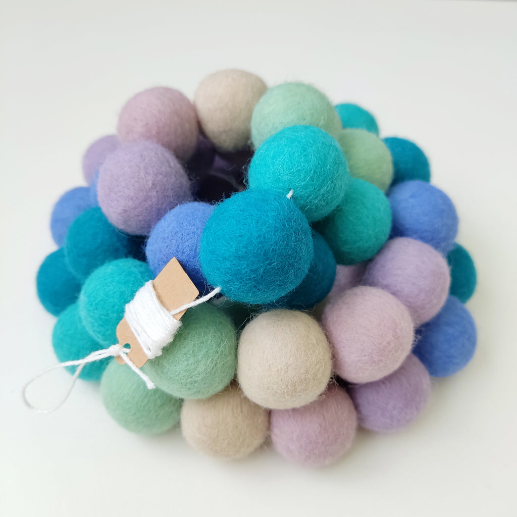 Zoom sur la guirlande de pompons sirène avec étiquette