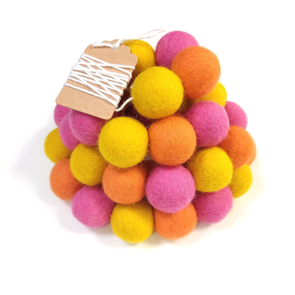 Zoom sur la guirlande de pompons en laine mérinos tutti frutti avec étiquette CELAINEDECO