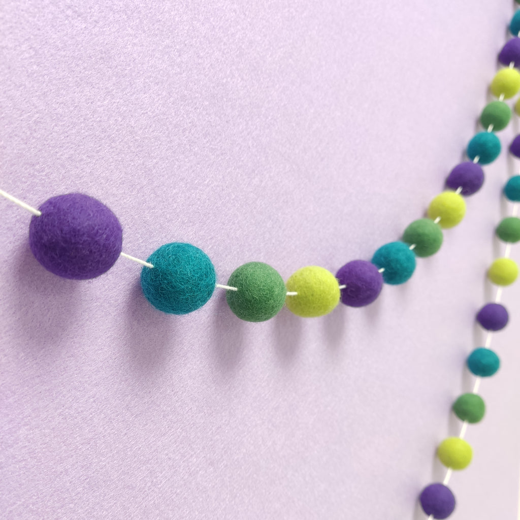 Guirlande de pompons en feutre de laine mérinos vert et violet vue de profil