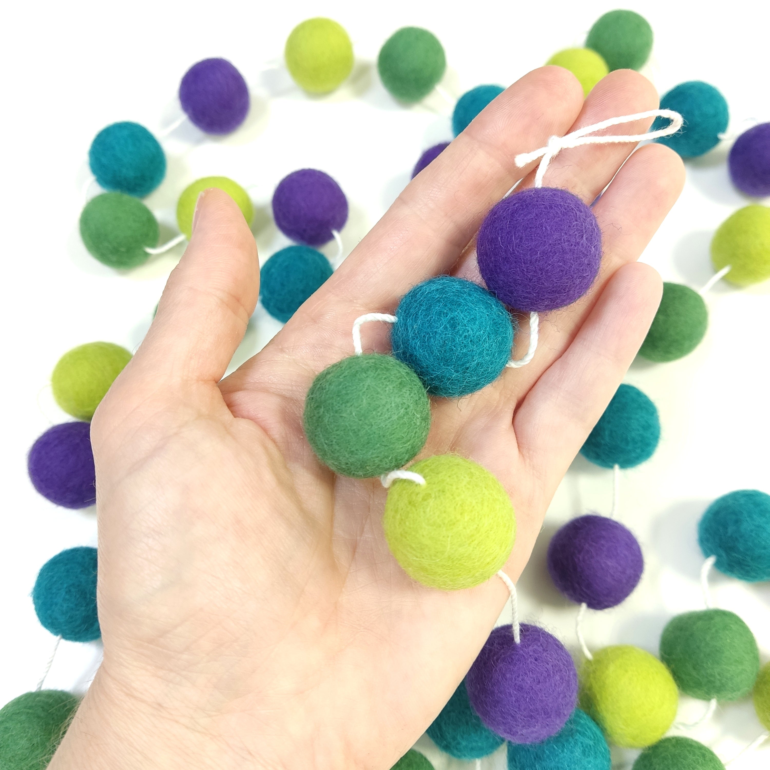 Détail des pompons feutrés de 2,5 cm dans une main