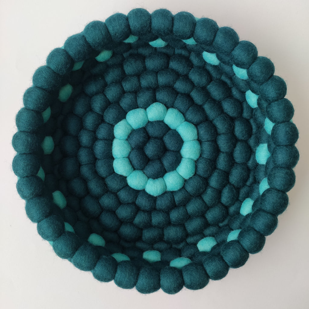 Panier rond pompons feutrés Horizon Marin vu de dessus – anneaux concentriques bleu pétrole et lagon
