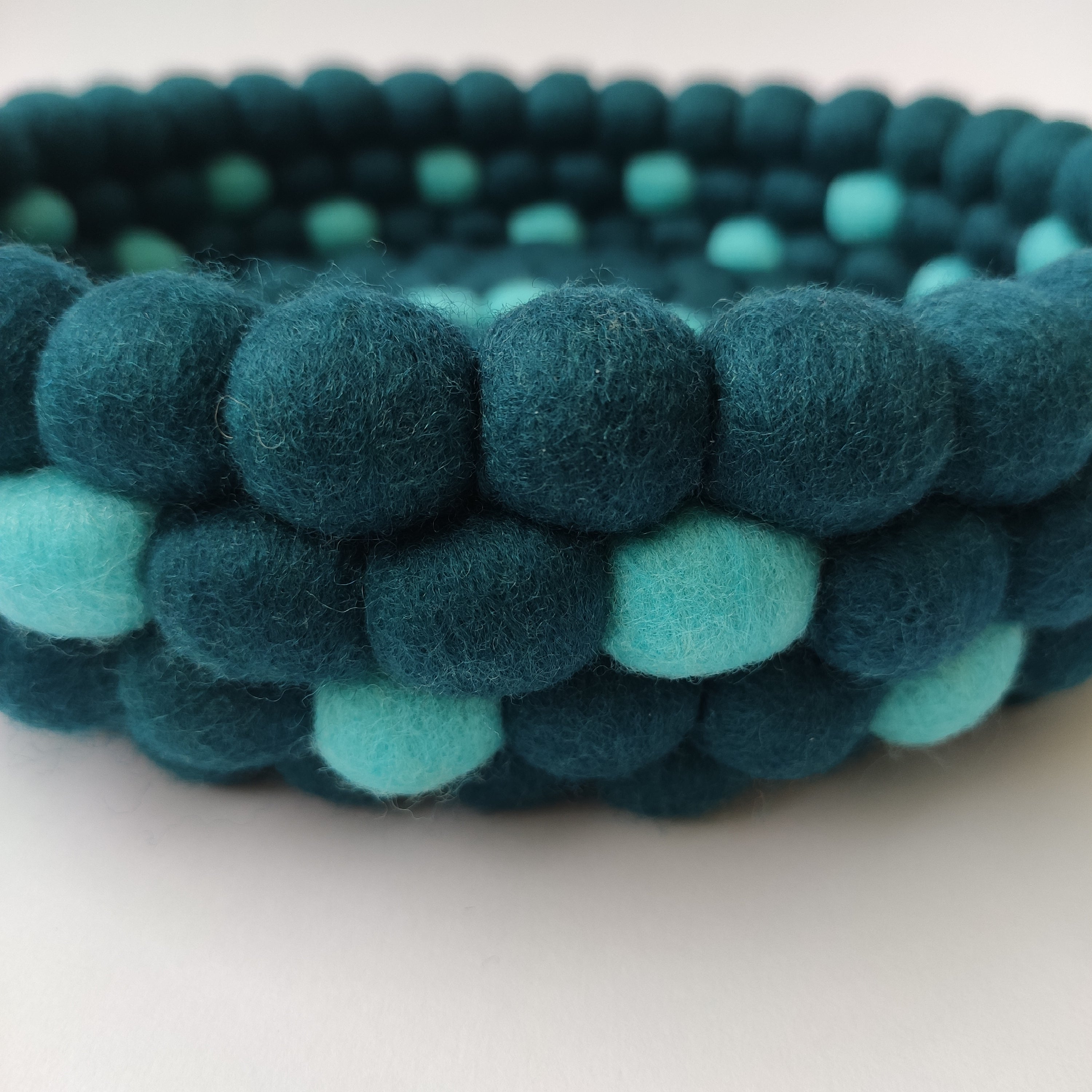 Détail pompons laine mérinos bleu pétrole et bleu lagon – panier Horizon Marin fait main
