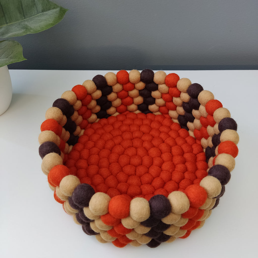 Détail des pompons feutrés beige, orange et brun du panier rétro vintage – CELAINEDECO