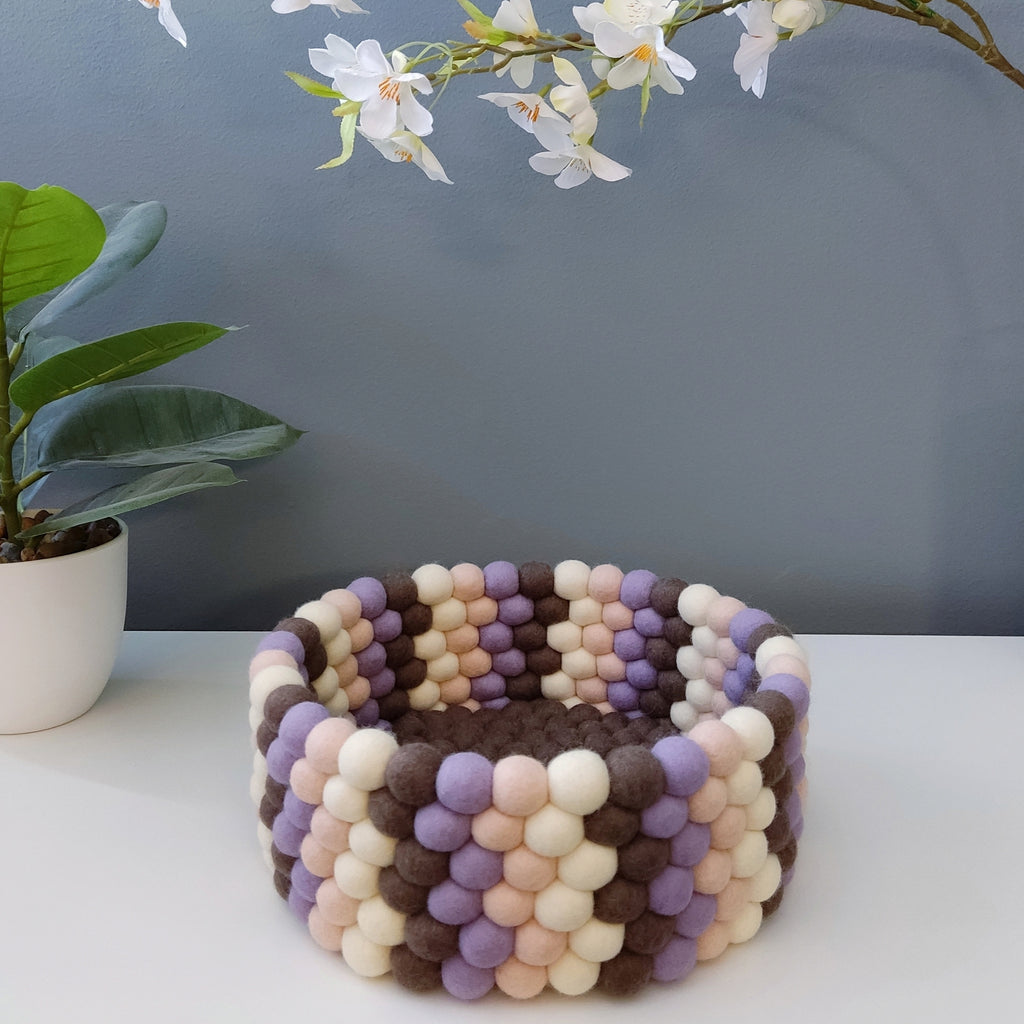 Panier en feutre Terre & Pétales – vue de face, pompons brun moka, lavande, beige rosé et blanc crème