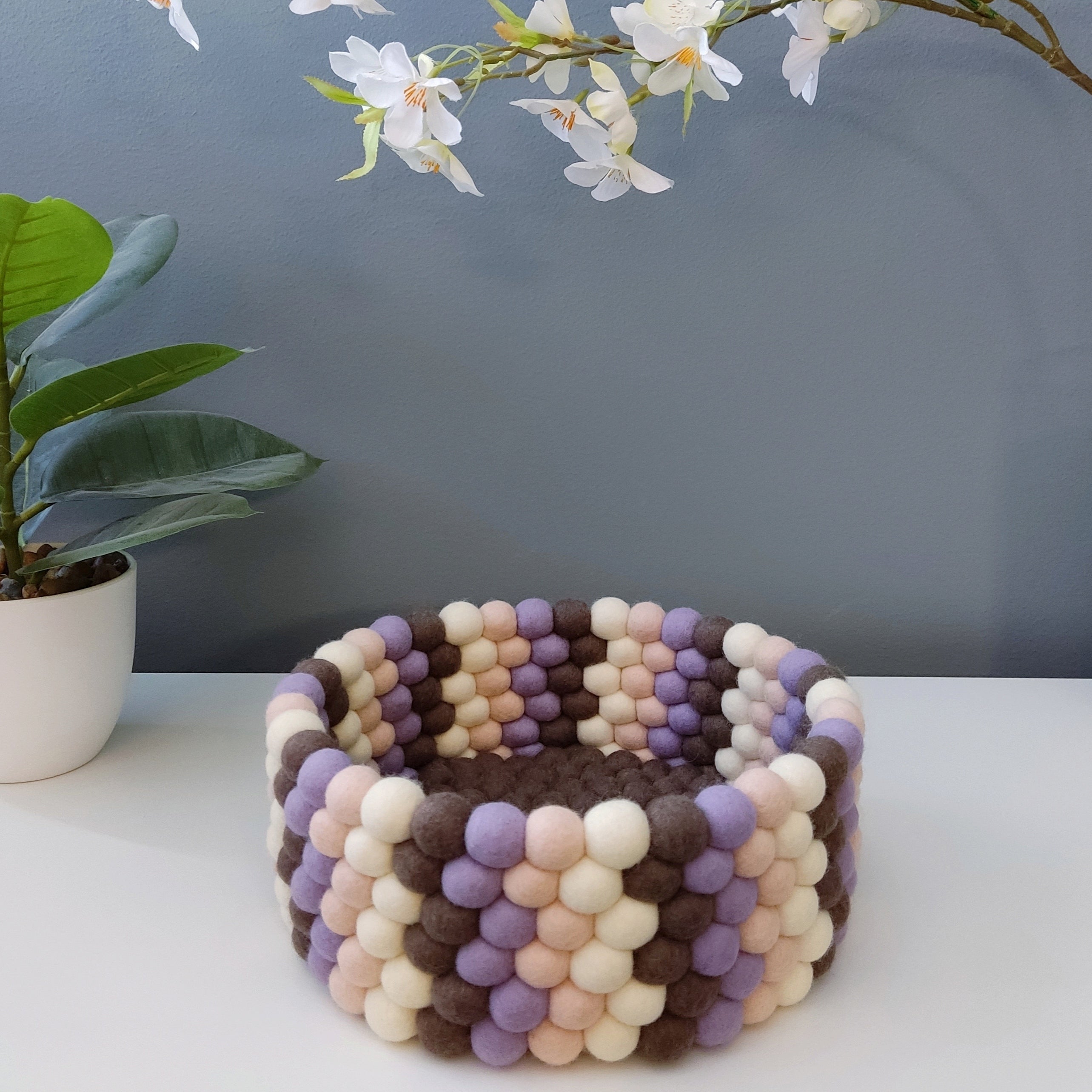 Panier en feutre Terre & Pétales – vue de face, pompons brun moka, lavande, beige rosé et blanc crème