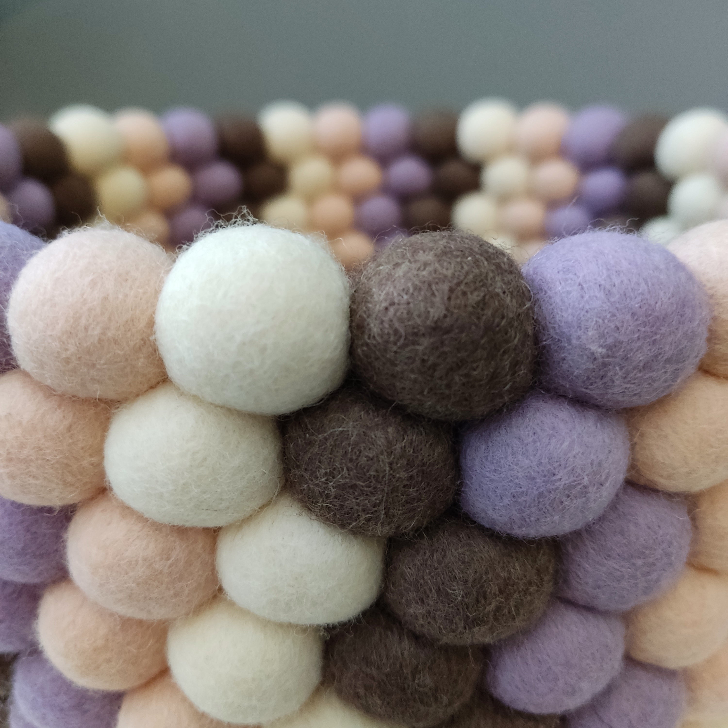 Zoom sur le panier décoratif en pompons feutrés – coloris Terre & Pétales, fait main