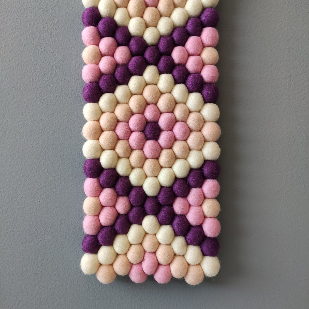 Zoom sur le tissage géométrique de la tapisserie Bahia – laine Mérinos tons violine et rose | CELAINEDECO