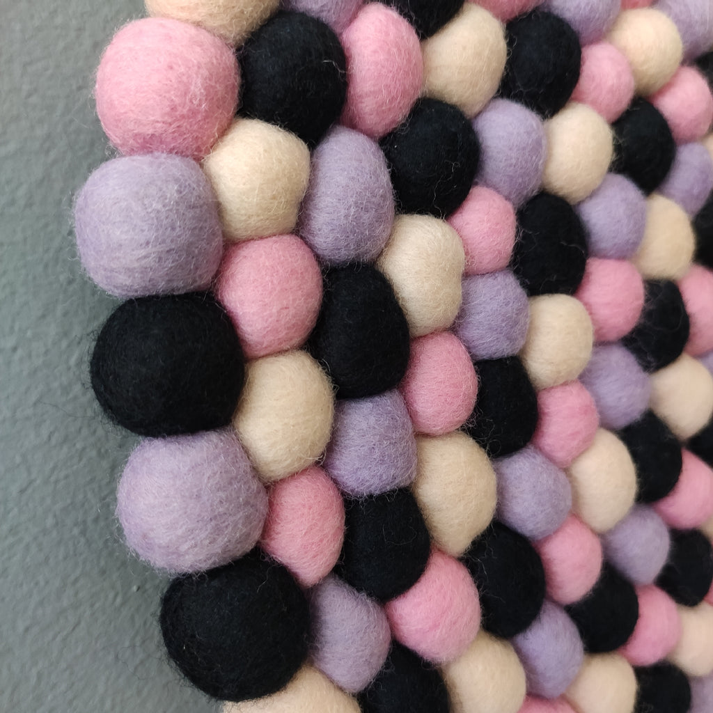 Tapisserie ronde Minuit Poudré – vue rapprochée pompons mauve, beige rosé et noir – pièce unique faite main en France – CELAINEDECO