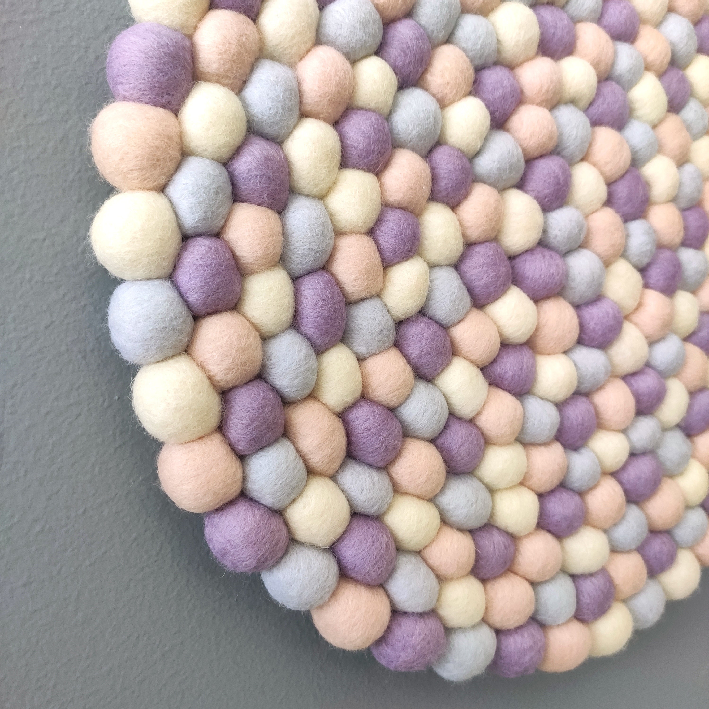 Détail de la tapisserie murale Nacre – mosaïque aléatoire de pompons Mérinos aux reflets nacrés et irisés – fait main en France