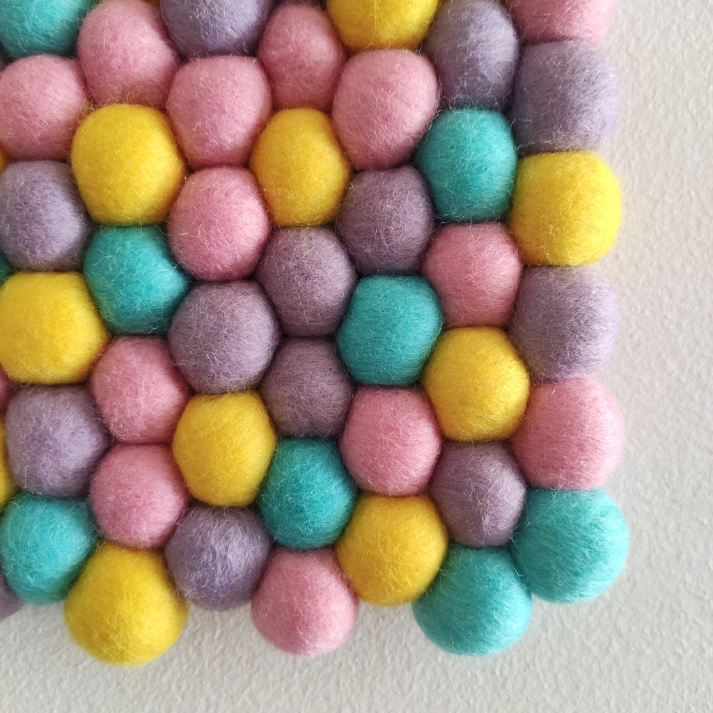 Détail de la tapisserie murale pixel pastel – pompons en laine feutrée colorés, fabrication artisanale française
