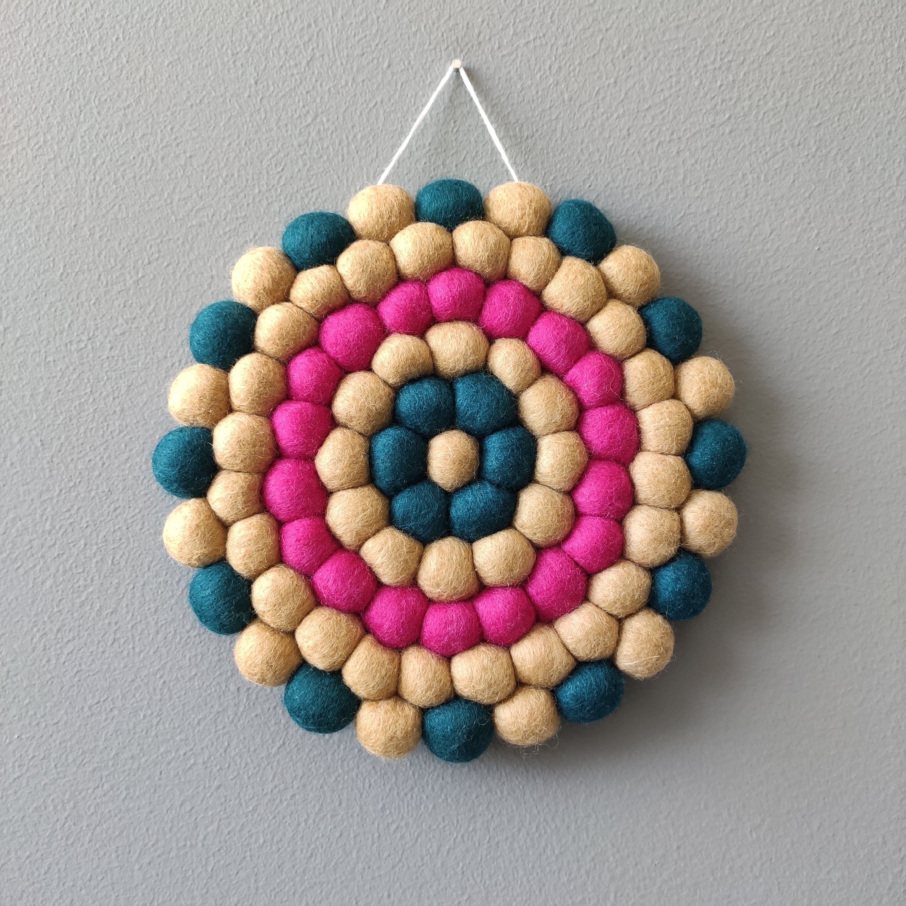 Tapisserie murale Vintage Bloom ronde beige dune, rose fuchsia et bleu pétrole sur un mur gris – CELAINEDECO