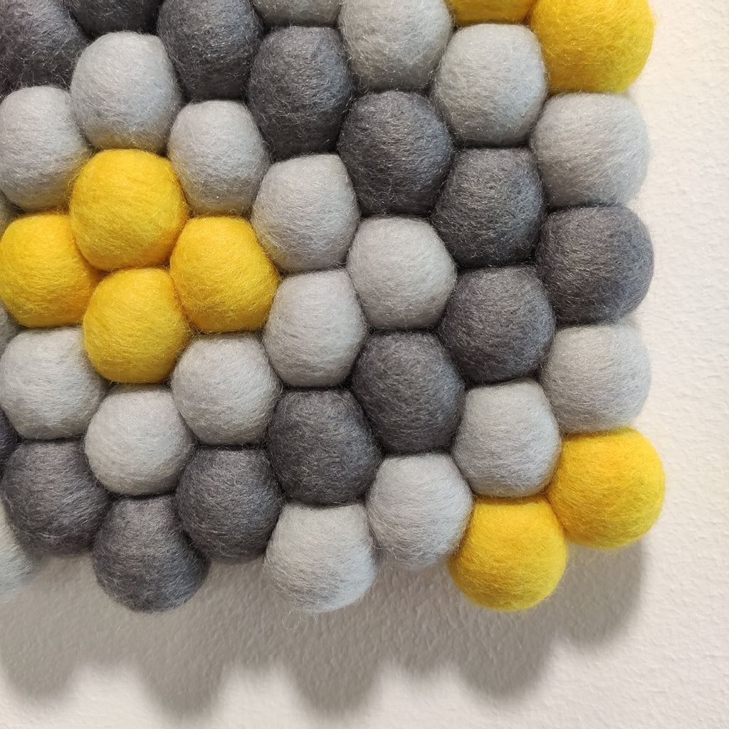 Tapisserie Zeste en laine Mérinos – motif géométrique gris et jaune citron – vue rapprochée pompons feutrés fait main – CELAINEDECO