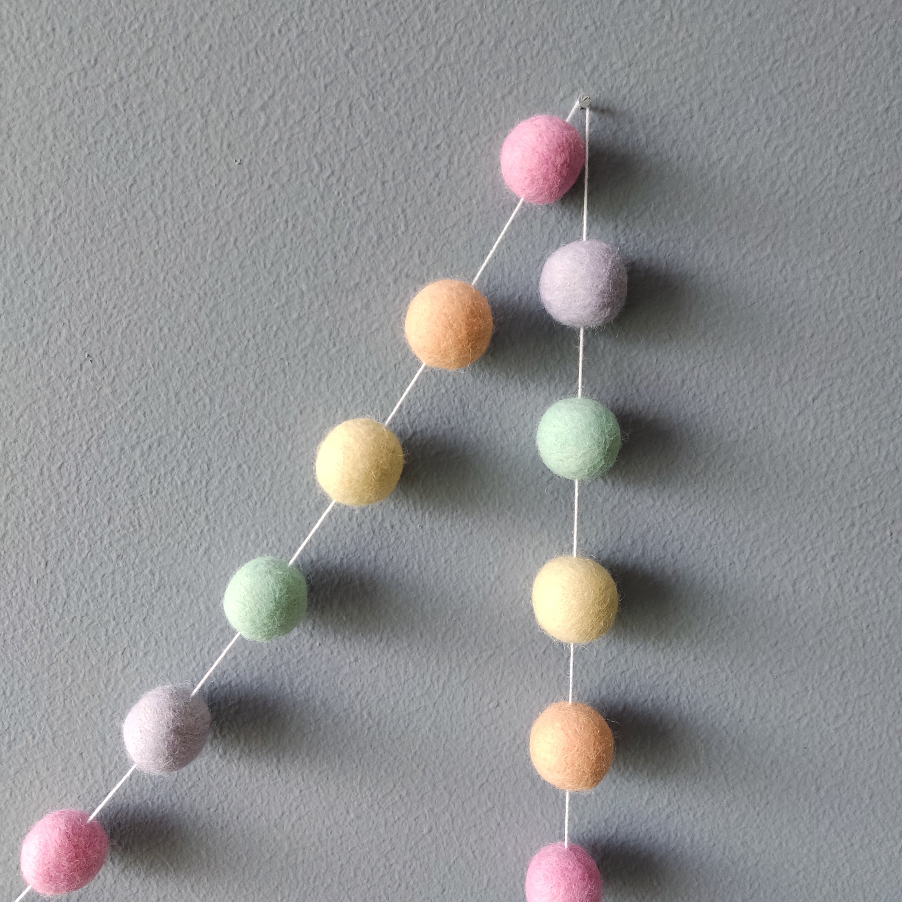 Guirlande de pompons aux couleurs pastel licorne vue de pres