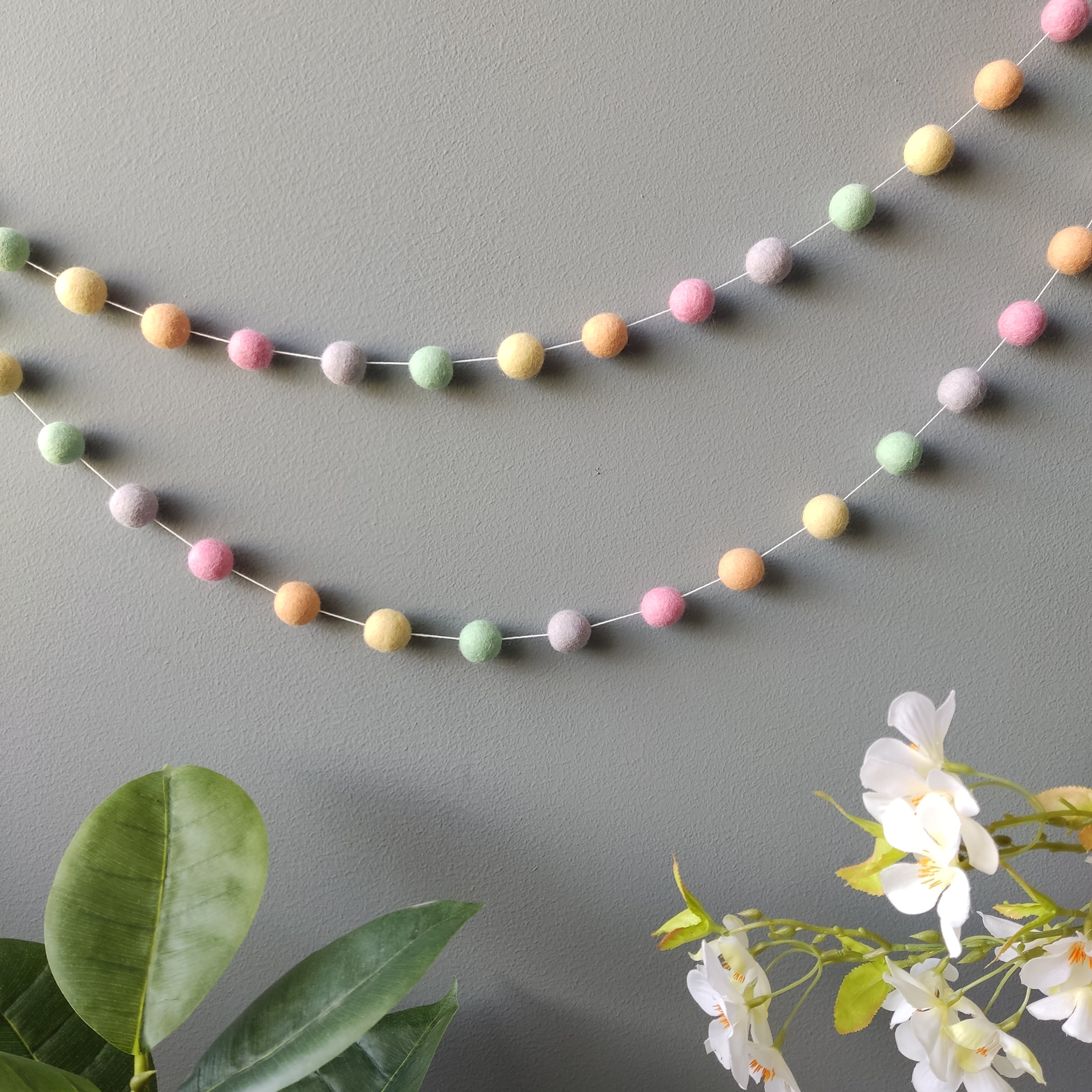 Guirlande de pompons aux couleurs pastel licorne vue de loin