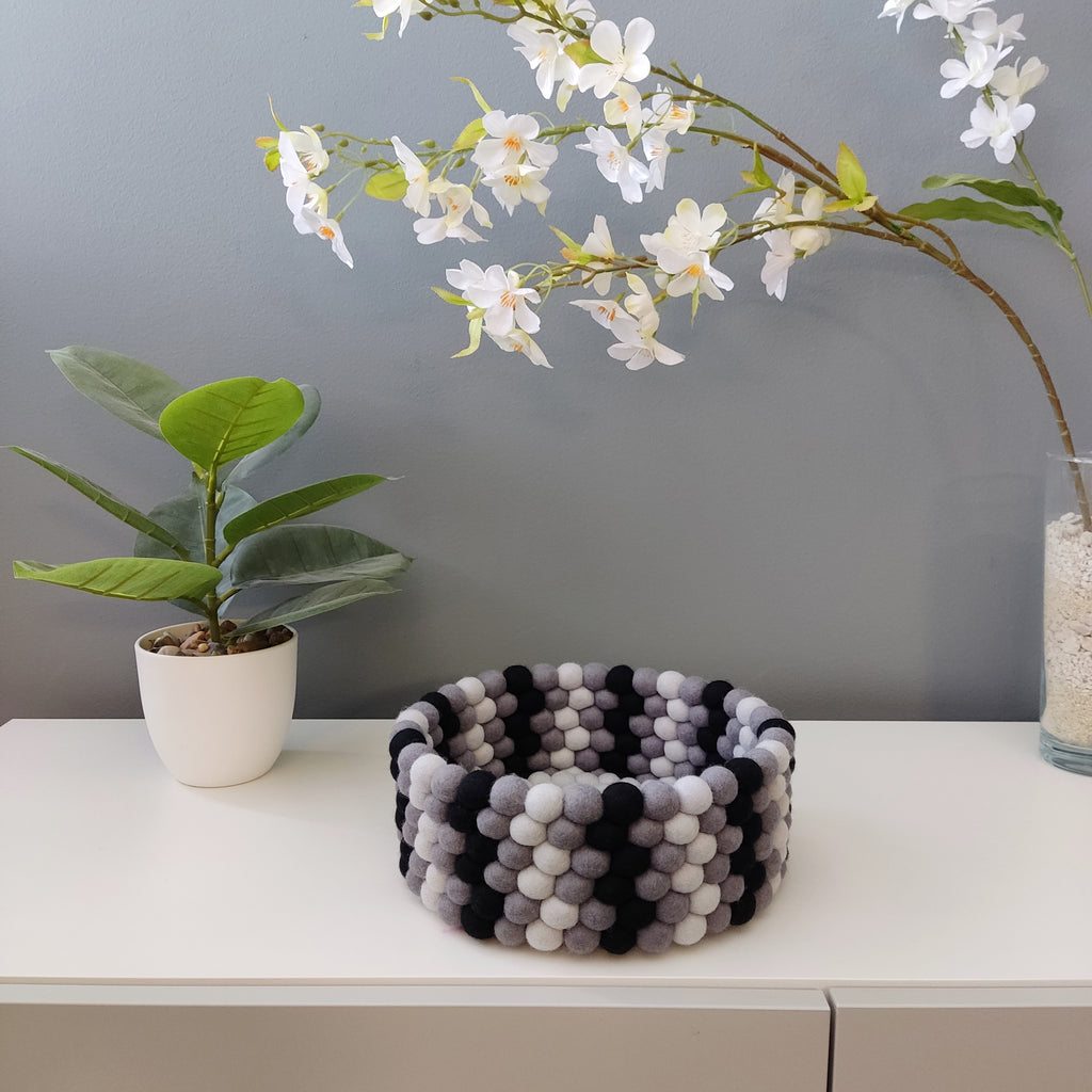 Panier en feutre Graphite & Perle – vue de présentation sur fond gris avec plante et orchidée – CELAINEDECO